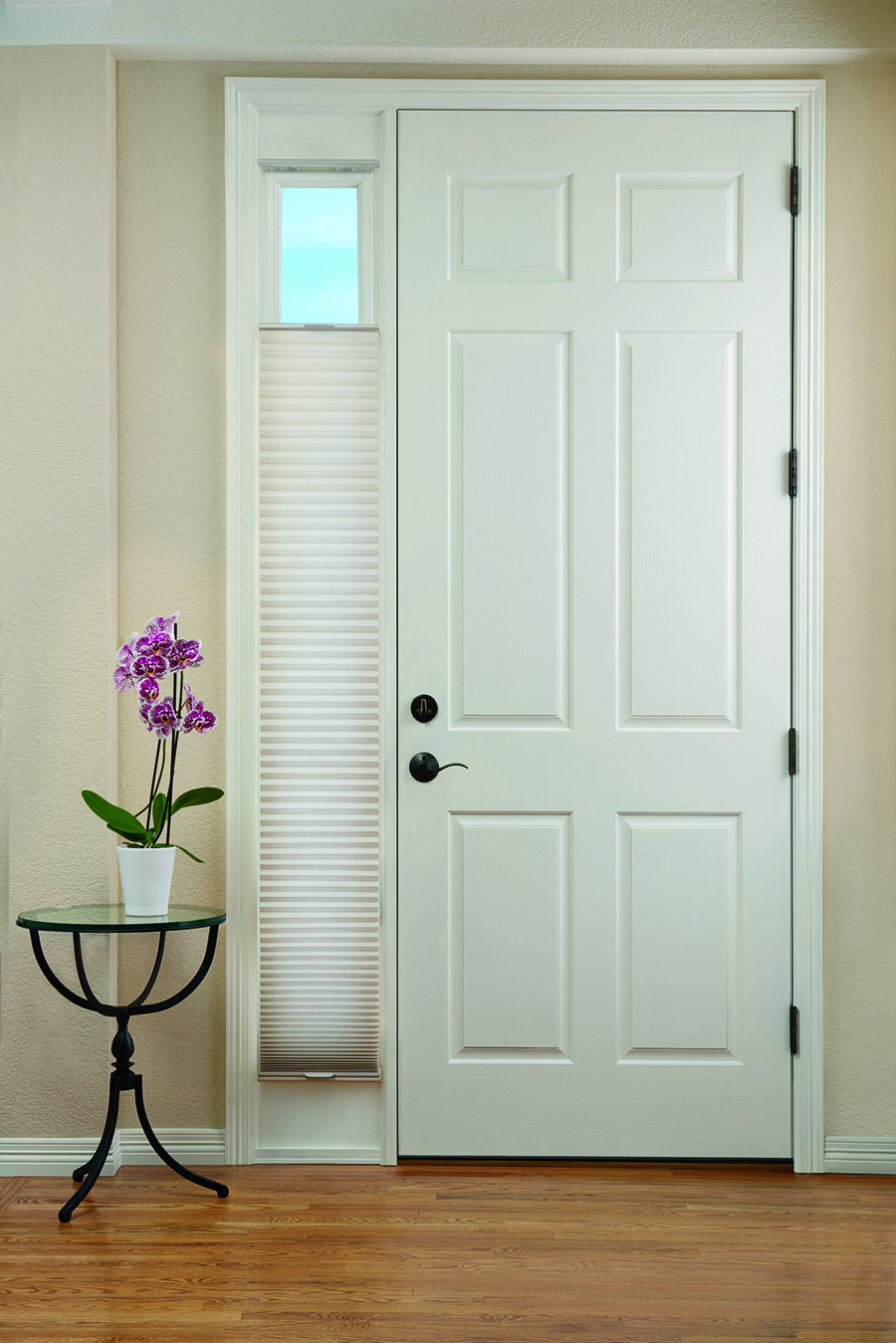 Entryway door with sidelight covered with honeycomb shades.