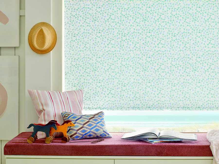 Window seat with patterned roller shades.