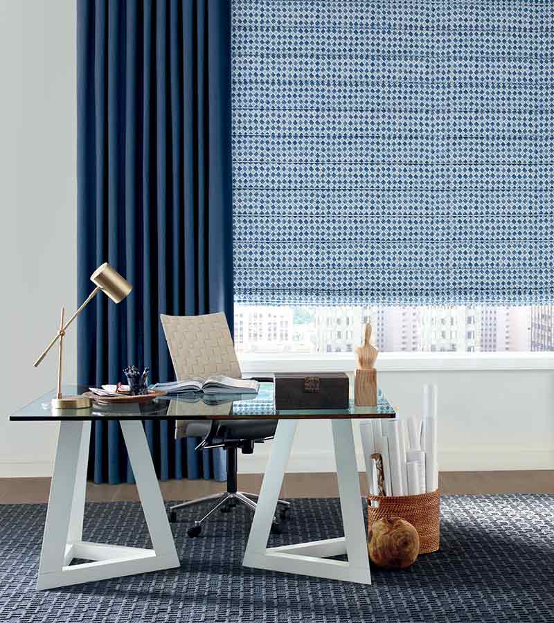 insulating window treatments with patterned blue roman shades and side draperies in Lee’s Summit 64086