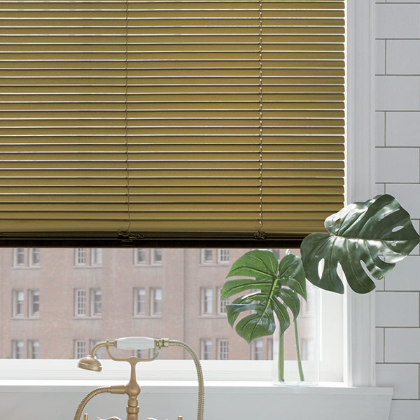 gold blinds in bathroom with monstera leaves in Kansas City MO