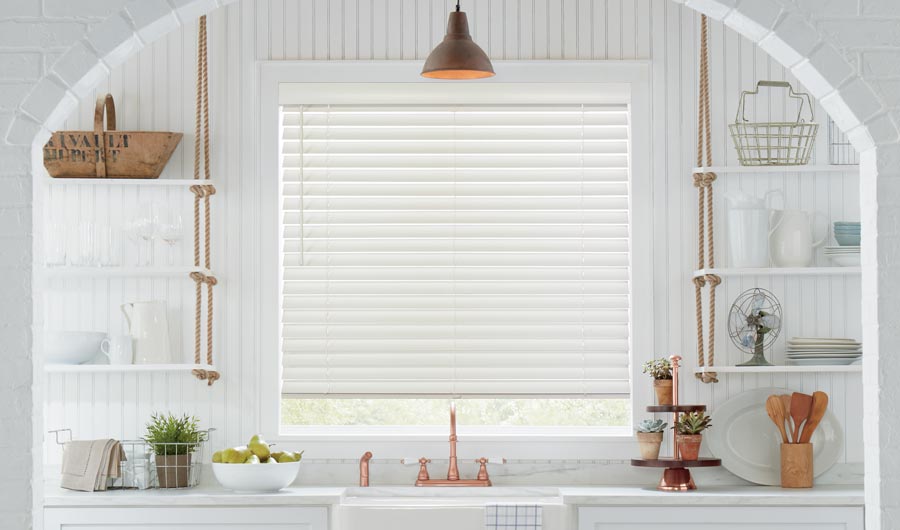 white kitchen with white blinds and warm gold accent lighting