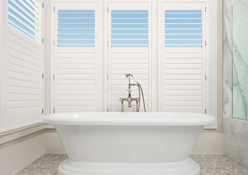 white bathroom with white hardwood shutters in Lee's Summit KS