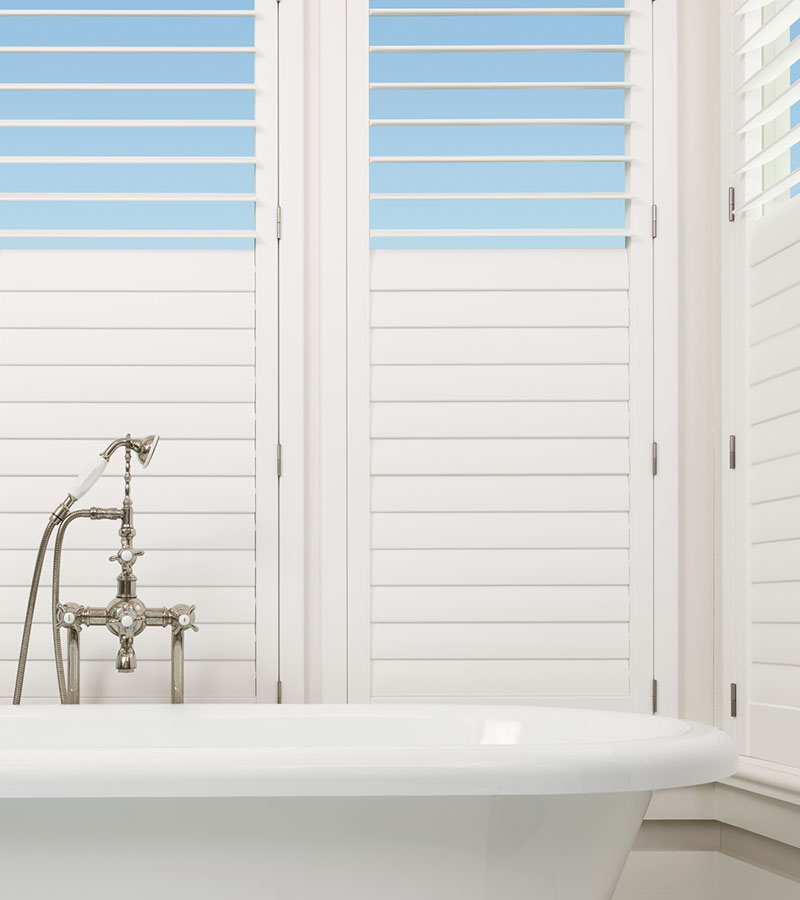 white bathroom with white hardwood shutters in Lee's Summit KS