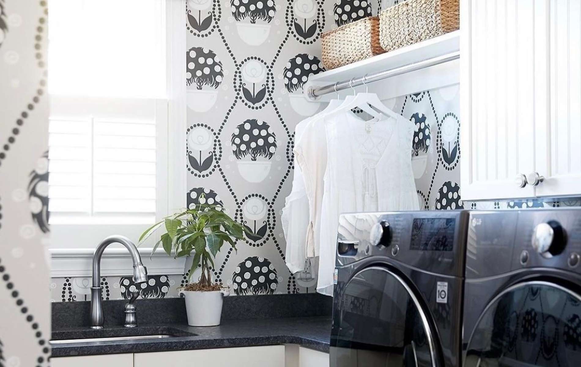 black and white laundry room with mixed floral pattern wall treatment