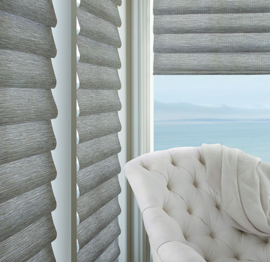 Gray roman shades on multiple floor to ceiling windows