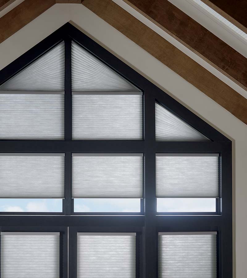 black framed triangular windows with honeycomb shades