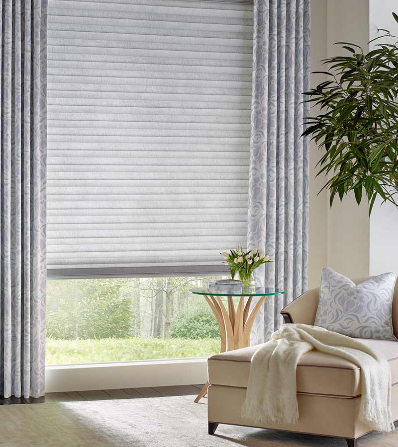 soft gray drapes with gray honeycomb cellular shades for energy efficiency in traditional living room