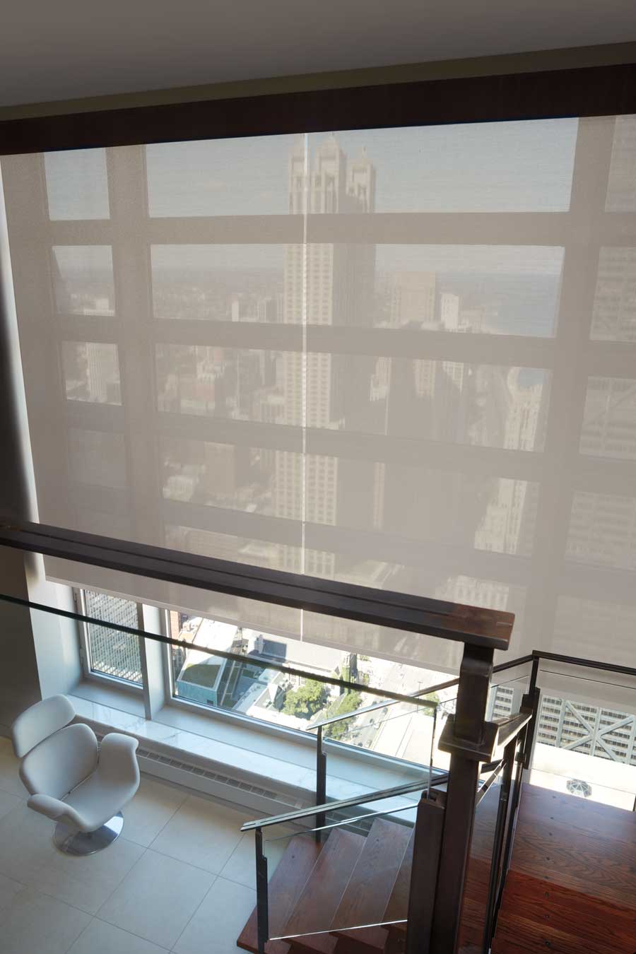 Designer Screen Shades on floor to ceiling windows in a big city penthouse