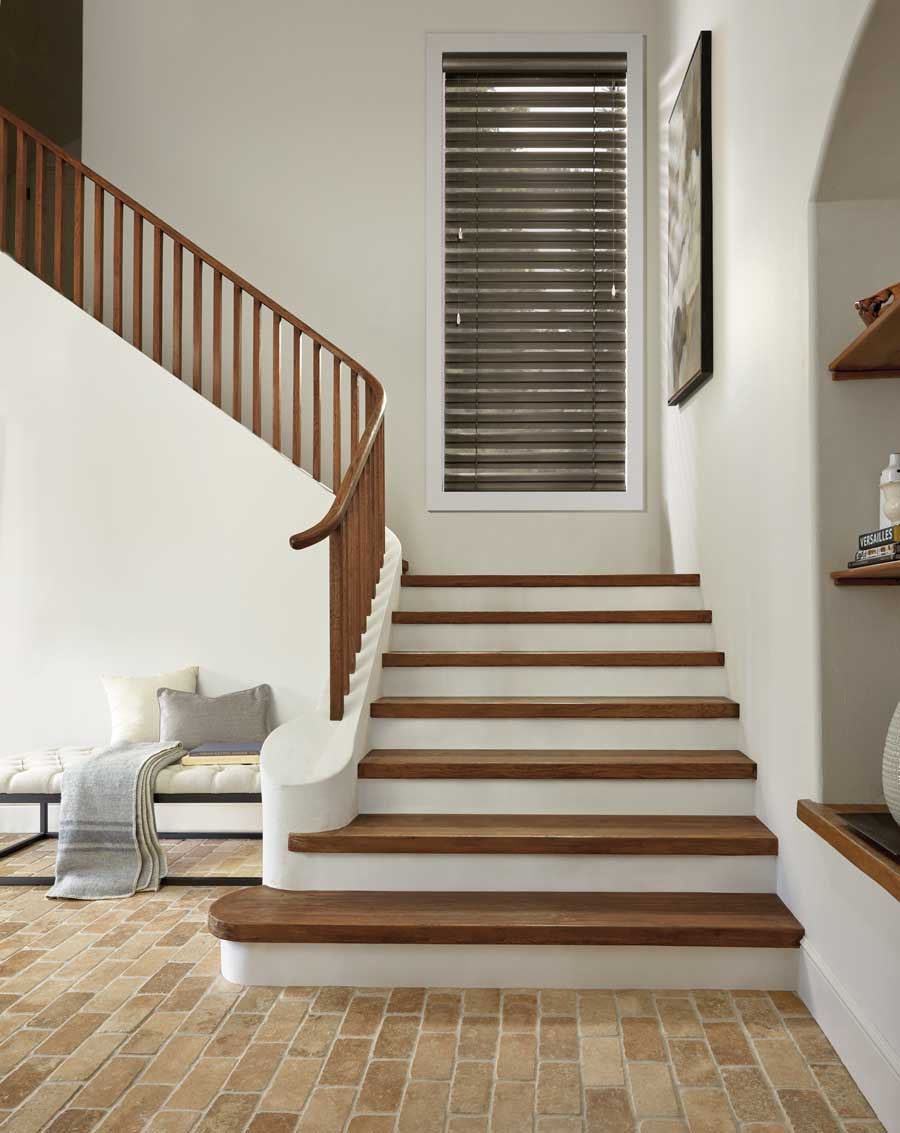 Modern Precious Metals® Aluminum Blinds on a window right above the first landing of a staircase.