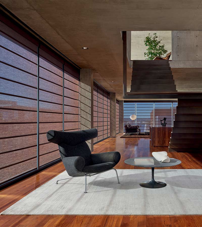 Contemporary loft apartment with maroon window shades and cherry wood accents