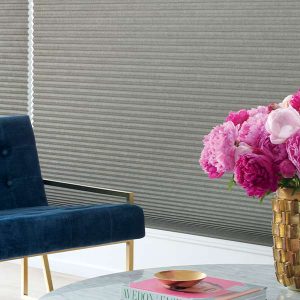 pink flowers next to floor to ceiling grey honeycomb shades