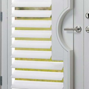 heritance-hardwood-shutter-bathroom-detail-one-stop-decorating detail of white shutters on patio door with chrome details